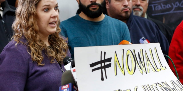 Furloughed National Park Service ranger Sean Ghazalam, second from left, listens as fellow furloughed park ranger Kathryn Gilson speaks during a press conference and rally, Thursday, Jan. 10, 2019, at La Colmena Center in the Staten Island borough of New York city. (AP Photo/Kathy Willens)