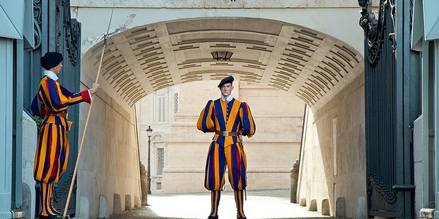 30 of April 2013. Rome, Vatican. Gate of St. Peter's Basilica which is guarded by Swiss Guards. The guard stands in the centre of the gate.