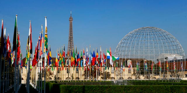 FILE - In this Tuesday Oct. 31, 2017 file picture, the Eiffel Tower, country flags and the Dome are seen from the garden of the United Nations Educational, Scientific and Cultural Organisation (UNESCO) headquarters building during the 39th session of the General Conference at the UNESCO headquarters in Paris, France. The United States and Israel have quit the U.N.’s educational, scientific and cultural agency, arguing the organization fosters anti-Israel bias. (AP Photo/Francois Mori, File)