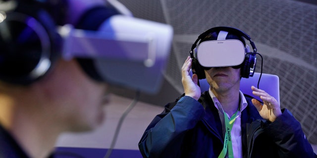 People use Oculus VR headsets at the Panasonic booth at CES International, Tuesday, Jan. 8, 2019, in Las Vegas. (AP Photo/John Locher)