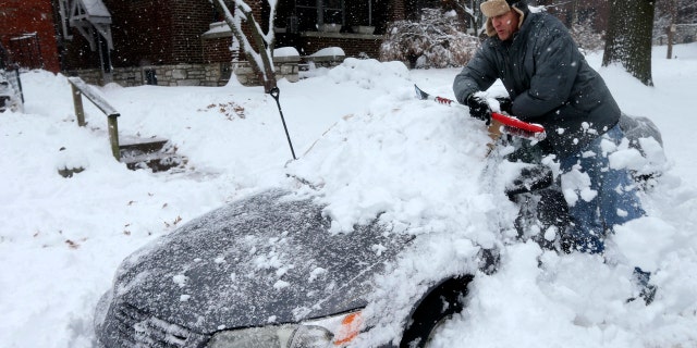 Jeff Clifford digs out his girlfriend's car from a pile of snow on Saturday, Jan. 12, 2019, in St. Louis.