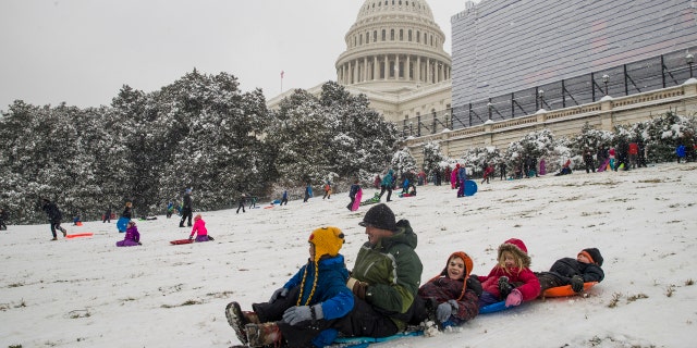 People sled on Capitol Hill as a winter storm arrives in the region, Sunday, Jan. 13, 2019, in Washington.