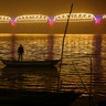 A person looks at an illuminated railway bridge across the river Yamuna ahead of the upcoming Kumbh Mela festival in Allahabad, India, Dec. 31, 2018. 