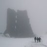 People walk past the ruins of a medieval castle on a foggy day in the Belarusian town of Novogrudok, Dec. 30, 2018. 