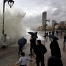 Residents play in front of waves crashing into the seawall in Beirut, Lebanon, Jan. 6, 2019. 