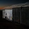 The sun sets while people walk next to the border fence between the U.S. side of San Diego and Tijuana, in Mexico, Jan. 2, 2019. 