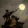 The supermoon rises above the 'Maritime Prowess' statue by Albert Hemstock Hodge on the Guild Hall ahead of the Lunar Eclipse, in Hull, England, Sunday, Jan. 20, 2019.
