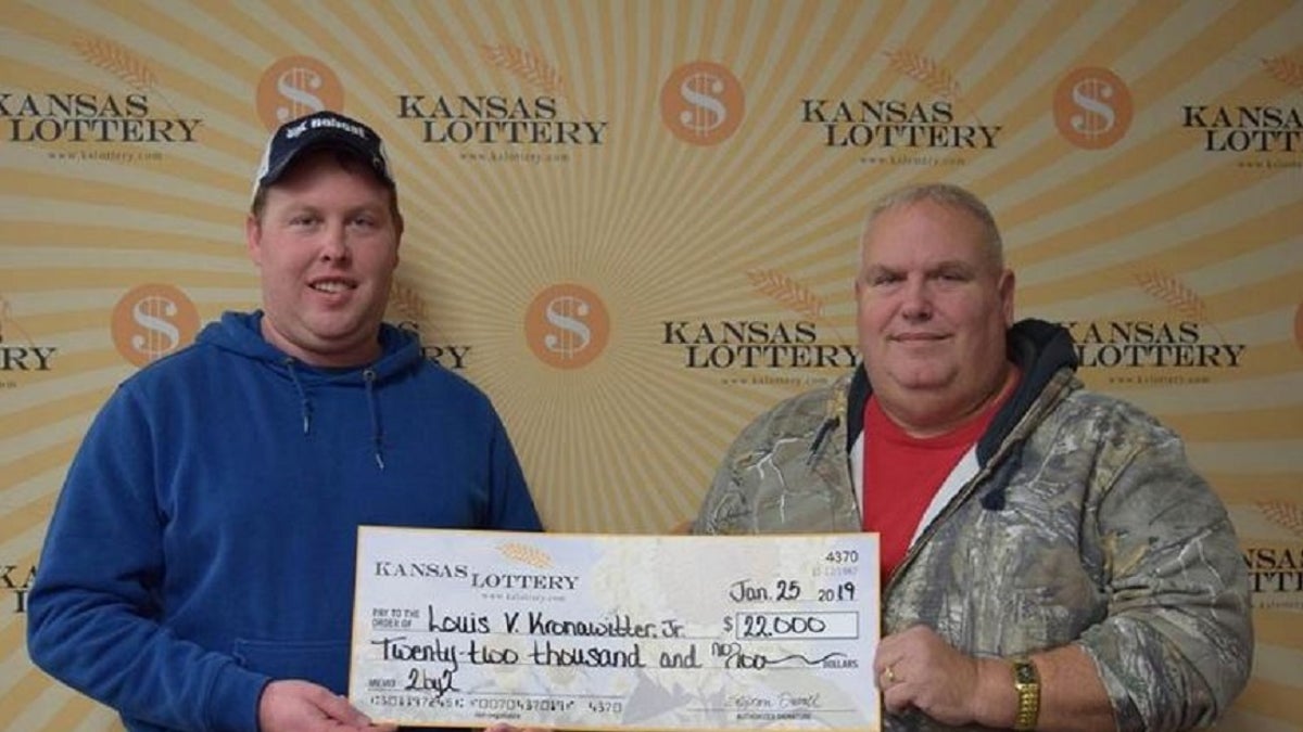 Kansas Lottery winner Louis V. Kronawitter Jr., right, and his son Austin Kronawitter pose with a $22,000 check. (Kansas Lottery)
