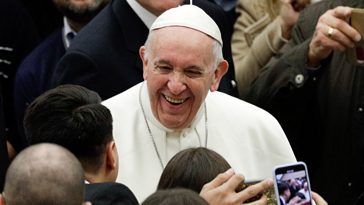 Pope Francis smiles as he arrives in the Paul VI hall on the occasion of his weekly general audience at the Vatican, Wednesday, Feb. 6, 2019. (AP Photo/Gregorio Borgia)