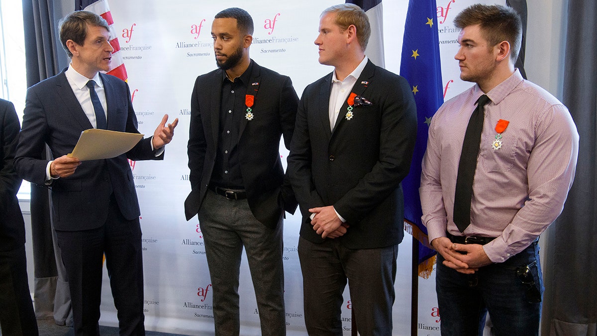French Consul General Emmanuel Lebrun-Damiens, left, honors Spencer Stone, Anthony Sadler, and Alek Skarlatos during a French Naturalization Ceremony in Sacramento, Calif., Thursday, Jan. 31, 2019. The three men were heralded as heroes when they subdued an armed terrorist on a train in France in 2015. Today they were granted French citizenship. (AP Photo/Randall Benton)