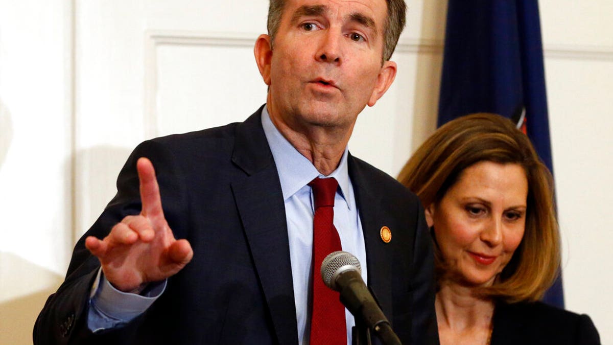 Virginia Gov. Ralph Northam, left, gestures as his wife, Pam, listens during a news conference in the Governors Mansion at the Capitol in Richmond, Va., Saturday, Feb. 2, 2019. Northam is under fire for a racial photo the appeared in his college yearbook. (AP Photo/Steve Helber)