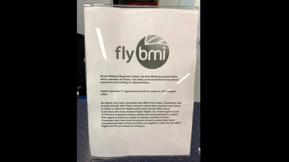 A notice informing passengers that Flybmi flights have been cancelled following the collapse of the airline, at Bristol Airport in Bristol, England, Sunday, Feb. 17, 2019.  (PA via AP)