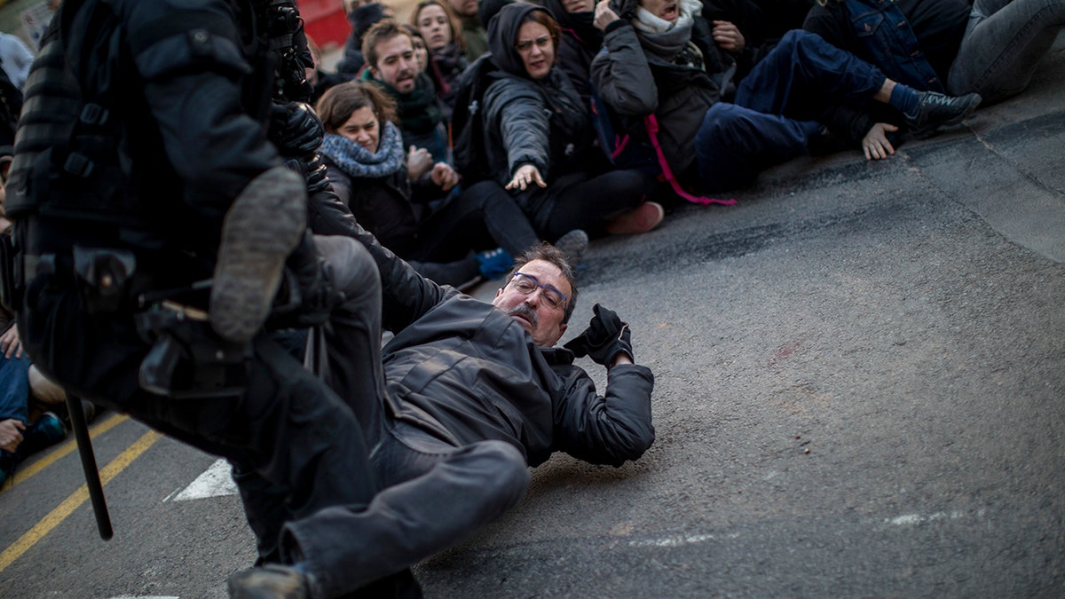 Authorities said one protester was arrested for allegedly hitting a police officer in downtown Barcelona, while a second person was arrested on a highway north of the city where protesters burned tires and threw rocks at a line of riot police.