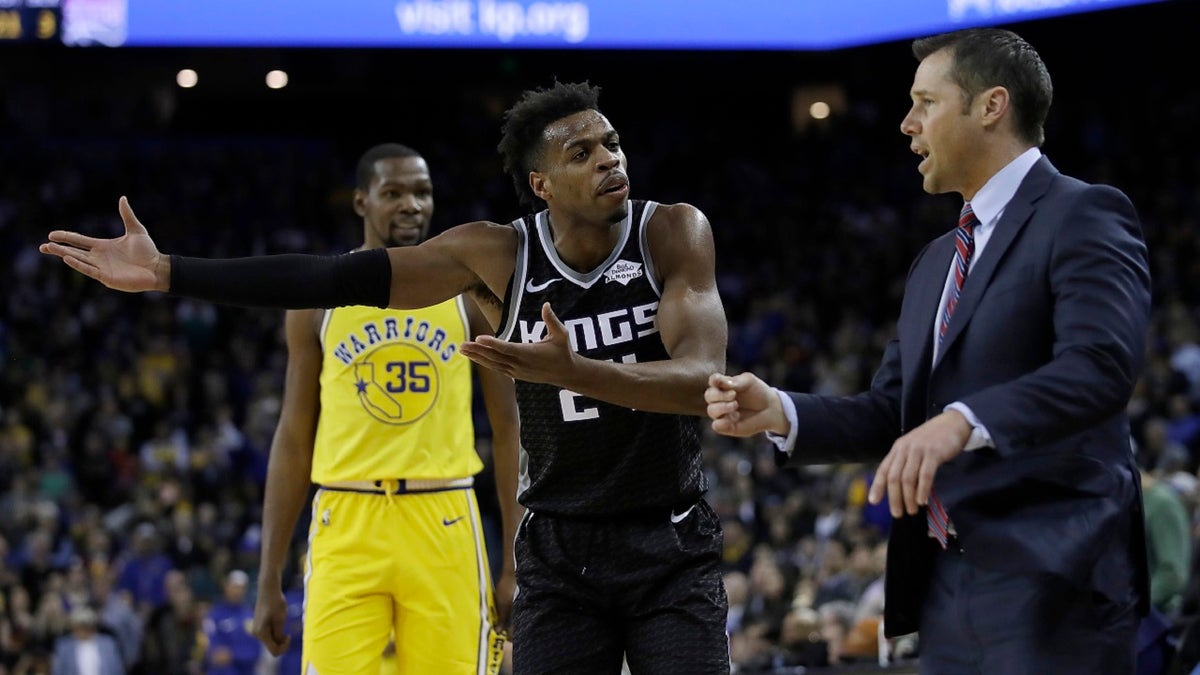 Sacramento Kings guard Buddy Hield, center, gestures to coach Dave Joerger, right, during the second half of the team's NBA basketball game against the Golden State Warriors on Thursday, Feb. 21, 2019, in Oakland, Calif.