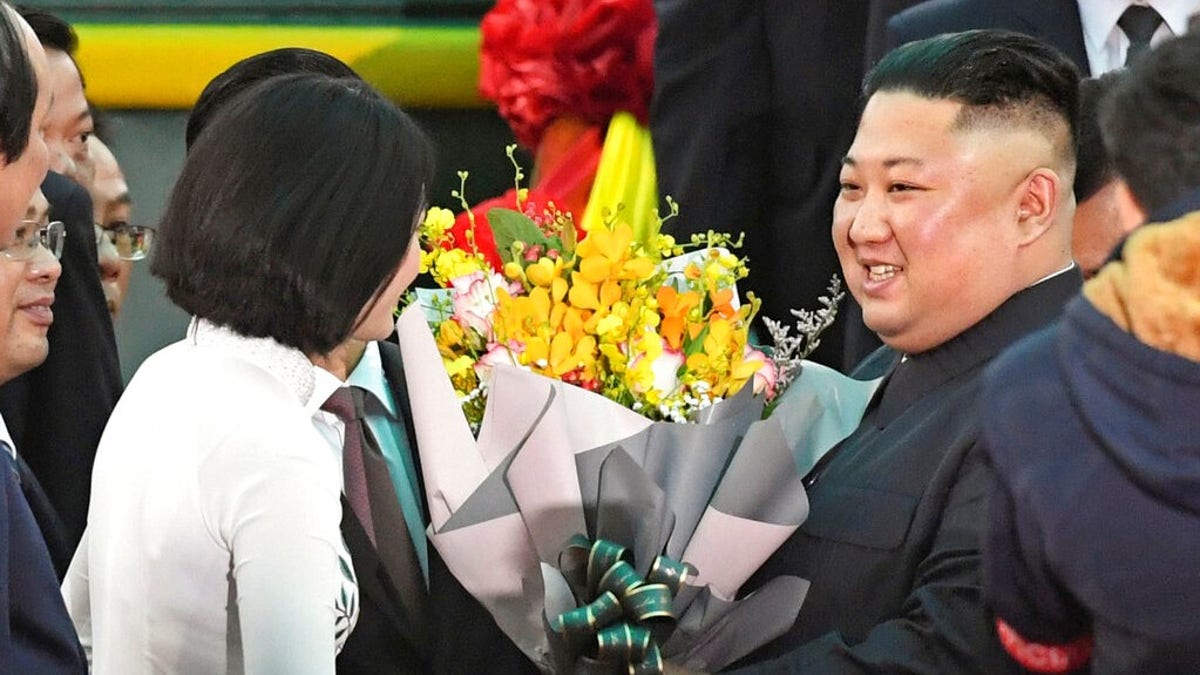 North Korean leader Kim Jong Un, right, receives bouquets on his arrival at the Dong Dang railway station in Dong Dang, a Vietnamese border town Tuesday.