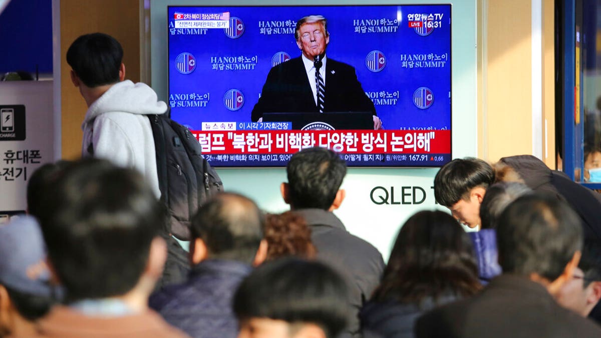 People watch a TV screen showing U.S. President Donald Trump's press conference, during a news program at the Seoul Railway Station in Seoul, South Korea, Thursday, Feb. 28, 2019.