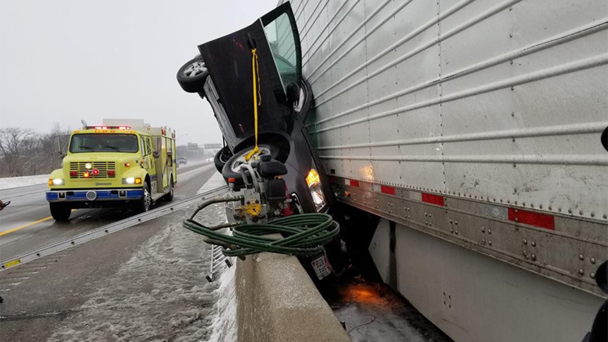 An Ohio fire department posted photos online of a car that was pinned between a highway barrier and a semi-truck.