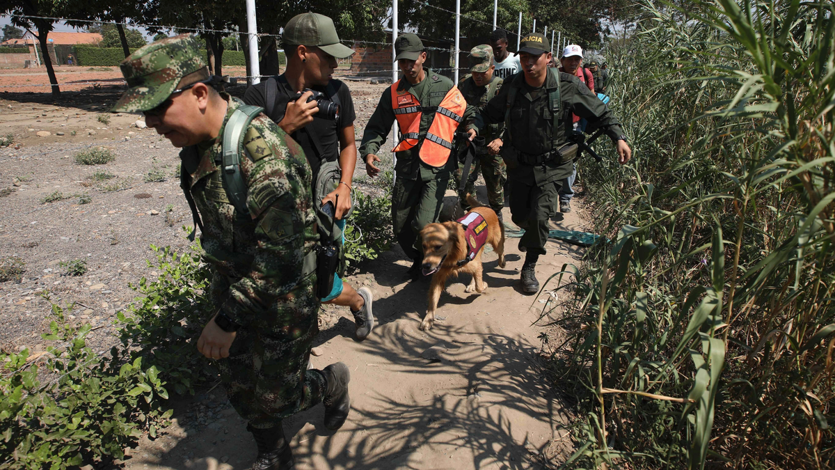 Colombian soldiers escort two Venezuelan National Guardsmen who deserted their post near the Simon Bolivar International Bridge, in La Parada, Colombia, Monday, Feb. 25, 2019. (AP Photo/Fernando Vergara)