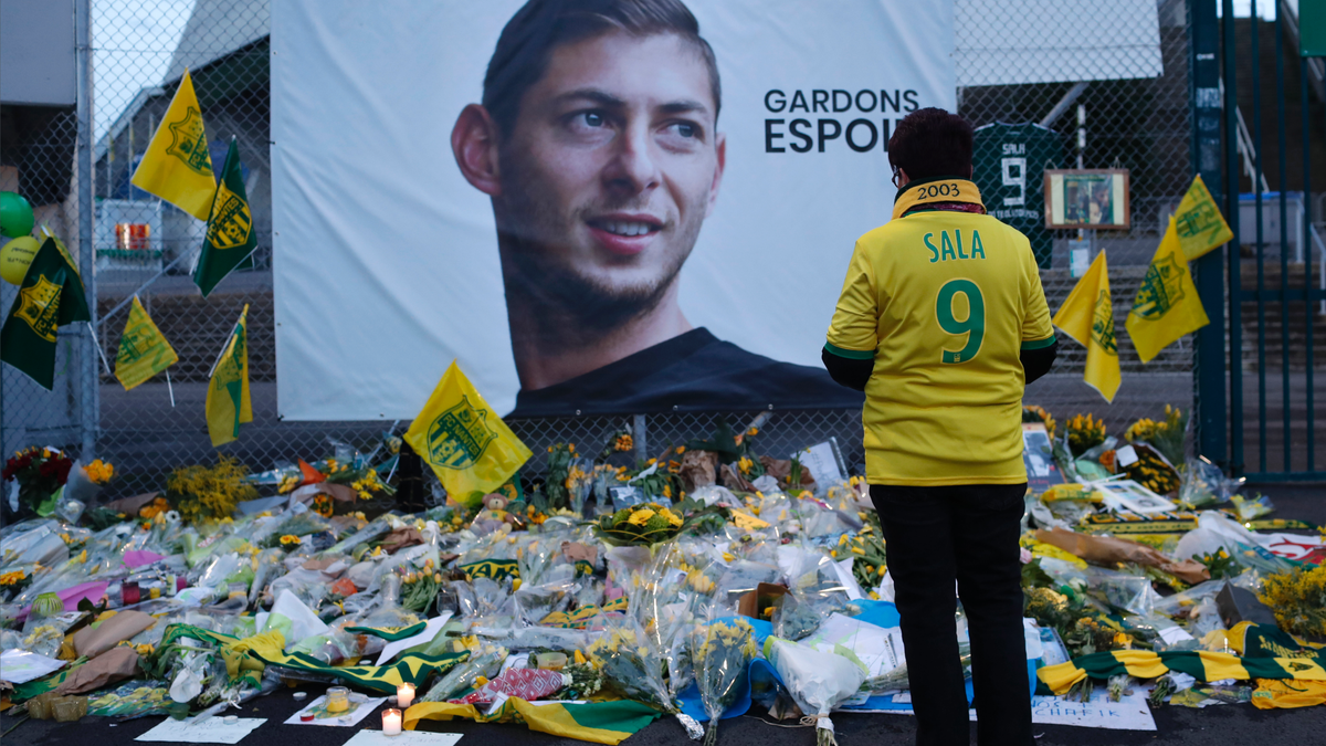 FILE - In this Wednesday, Jan. 30, 2019, file photo, a Nantes soccer team supporters stops by a poster of Argentinian player Emiliano Sala and reading "Let's keep hope" outside La Beaujoire stadium before the French soccer League One match Nantes against Saint-Etienne, in Nantes, western France.