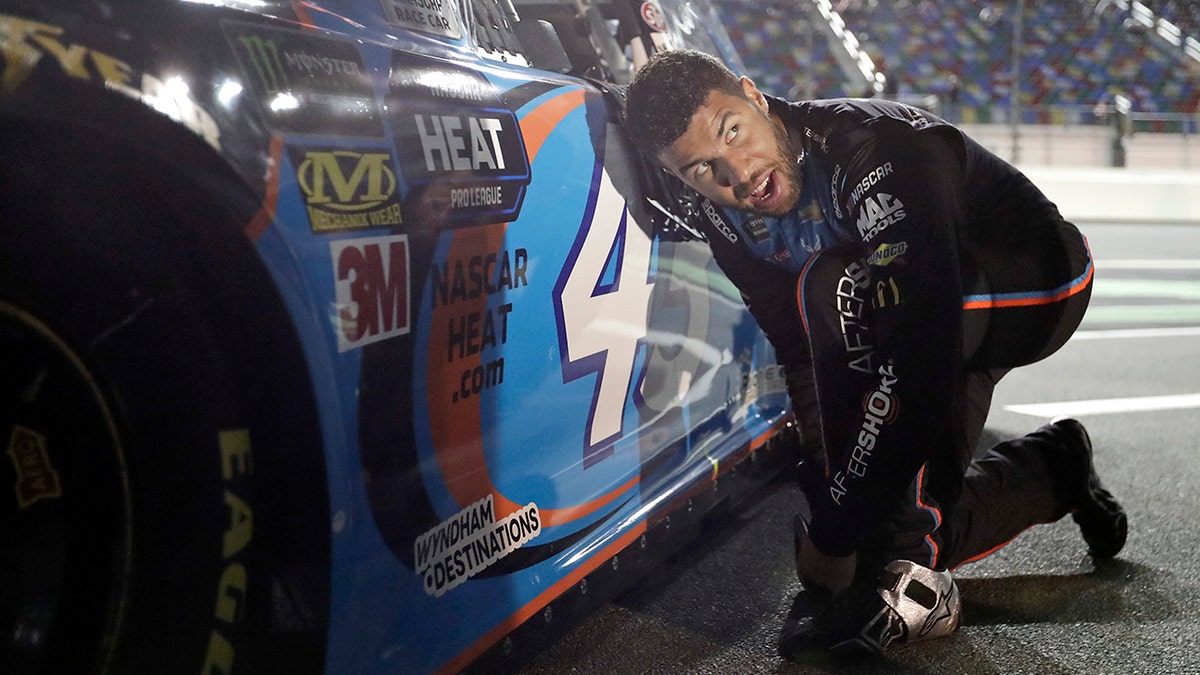 Darrell Wallace Jr. adjusts his driving shoes before getting into his car before the first of two qualifying auto races for the NASCAR Daytona 500 at Daytona International Speedway, Thursday, in Daytona Beach, Fla. (AP Photo/John Raoux)