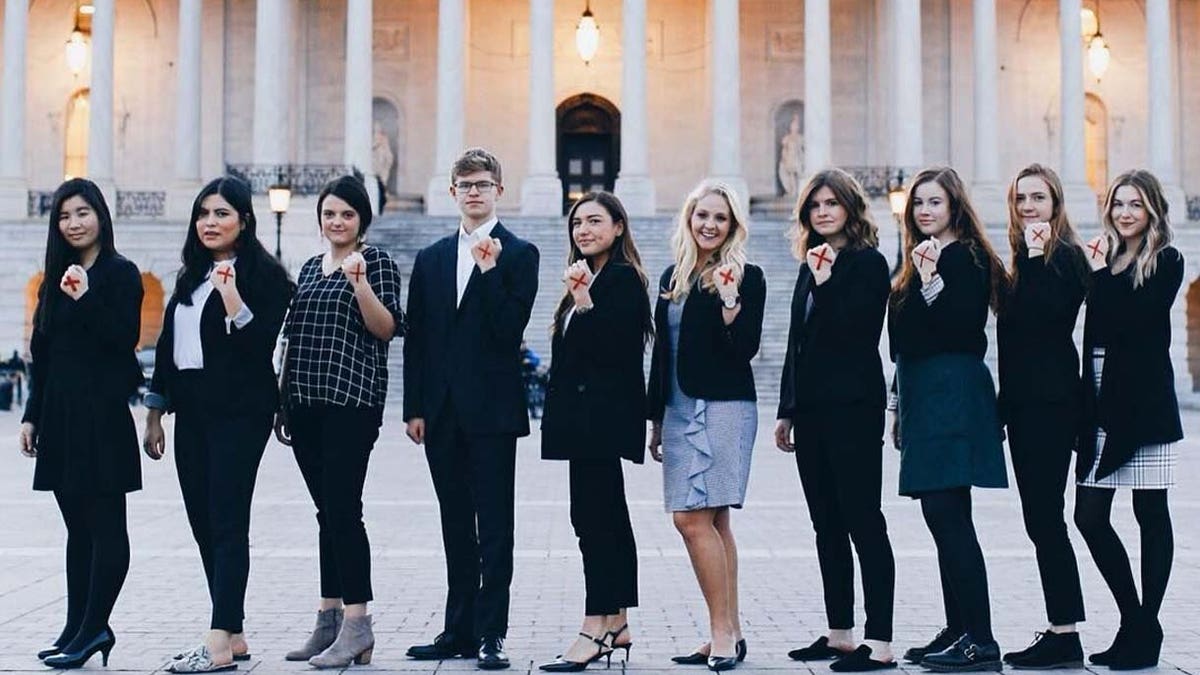 People participate in "Shine a Light on Slavery Day" by marking a red X on their hand.