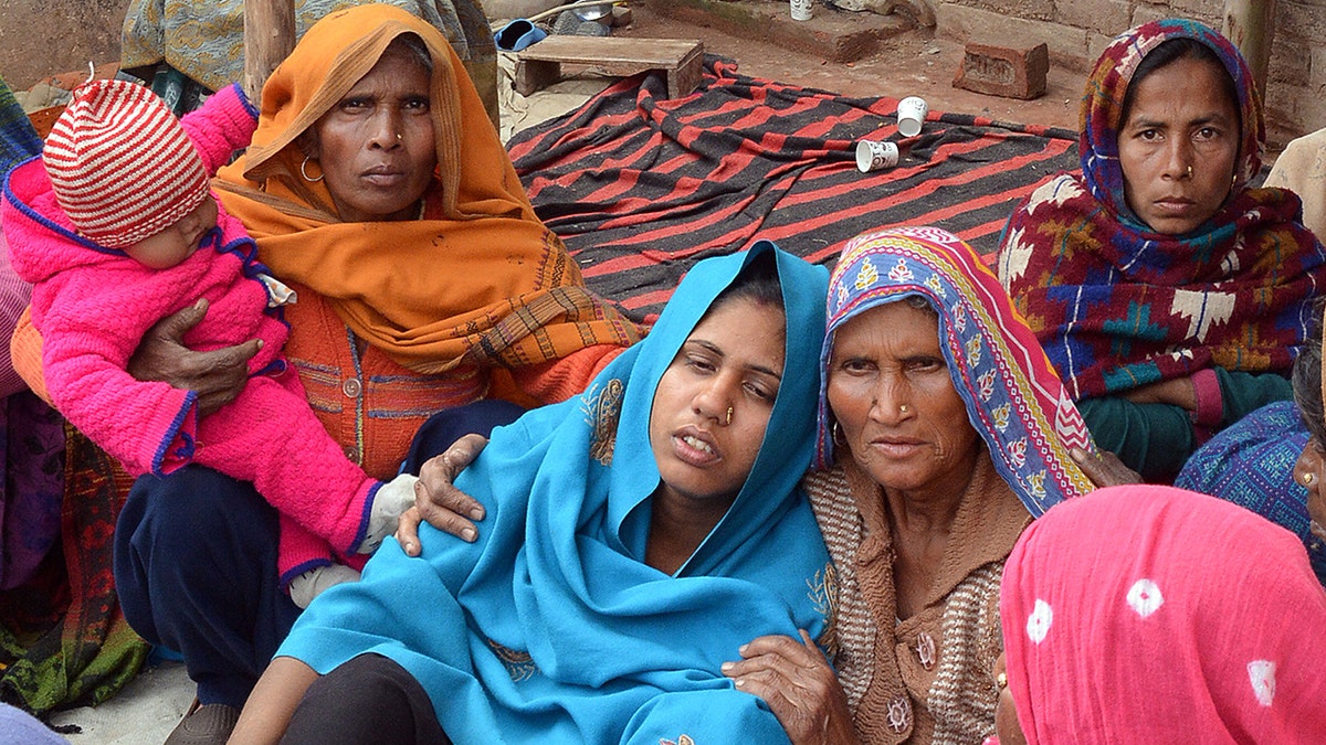 A woman is consoled after her husband's death from bootleg alcohol in Saharanpur, northern state of Uttar Pradesh, India February 11, 2019. REUTERS/Stringer - RC166AD33170