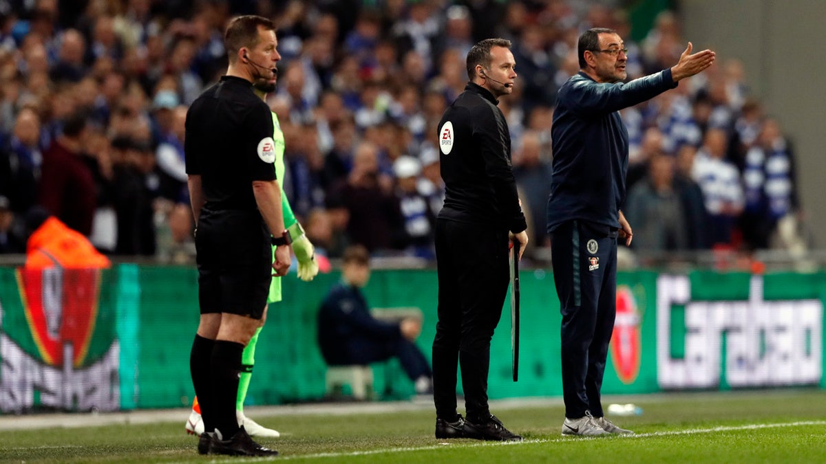 Chelsea's manager Maurizio Sarri, right, remonstrates with Kepa while substitute keeper Willy Caballero, obscured, waits to be subbed on. (AP Photo/Alastair Grant)