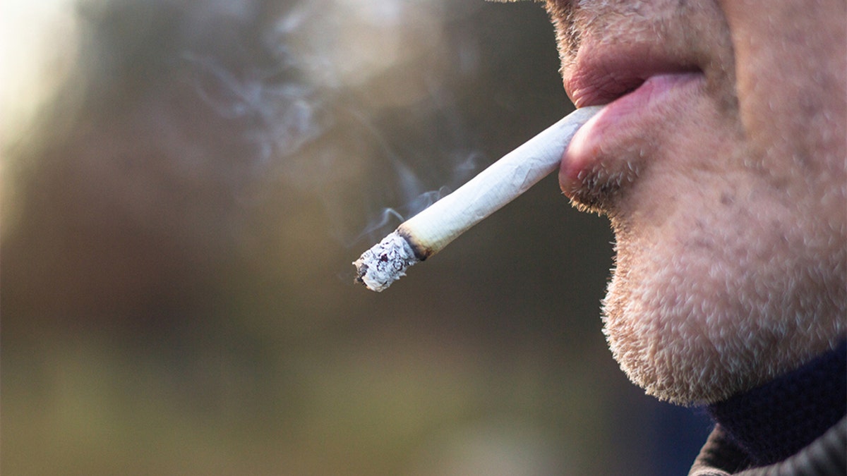 A man smokes a cigarette outdoors