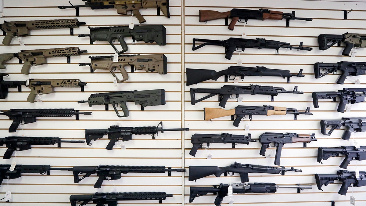 Semi-automatic rifles fill a wall at a gun shop in Lynnwood, Wash. (AP Photo/Elaine Thompson, File)