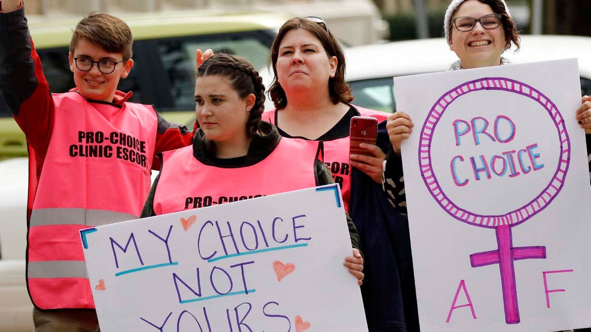 Abortion rights advocates hold signs in support of choice, at the Capitol in Jackson, Miss