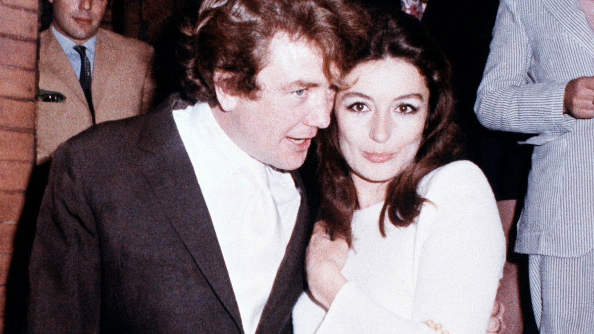 In this 1970 file photo, British actor Albert Finney embraces his bride, French actress Anouk Aimee, after their registry office wedding in London.