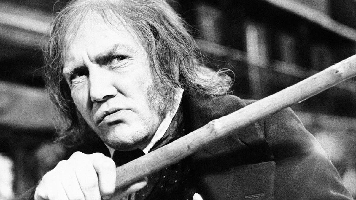 In this Jan. 15, 1970 file photo, British actor Albert Finney waves his cane while playing the title role in "Scrooge," at Shepperton Studios.