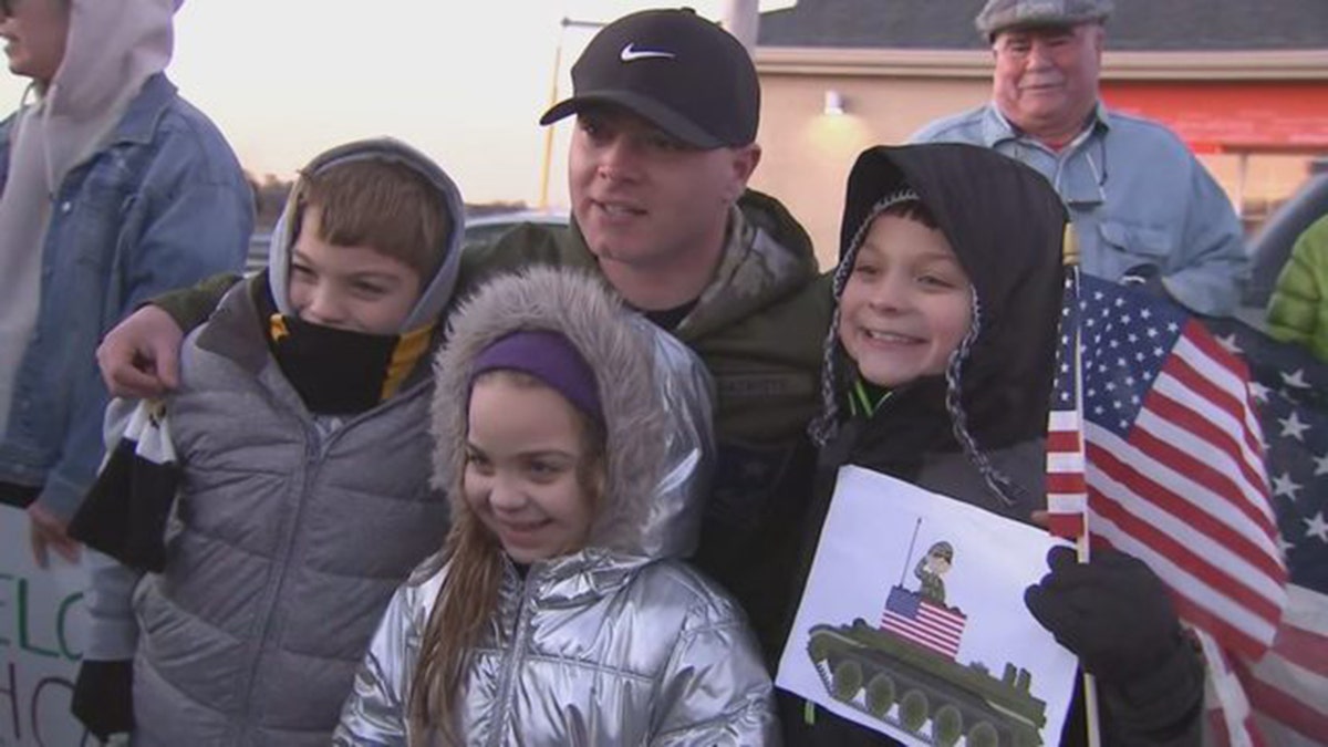 Beau Schlichting posed with young well-wishers at his suprising homecoming party Saturday in Winthrop, Mass. Schlichting returned home after a nine-month deployment in Afghanistan with the U.S. Army. 