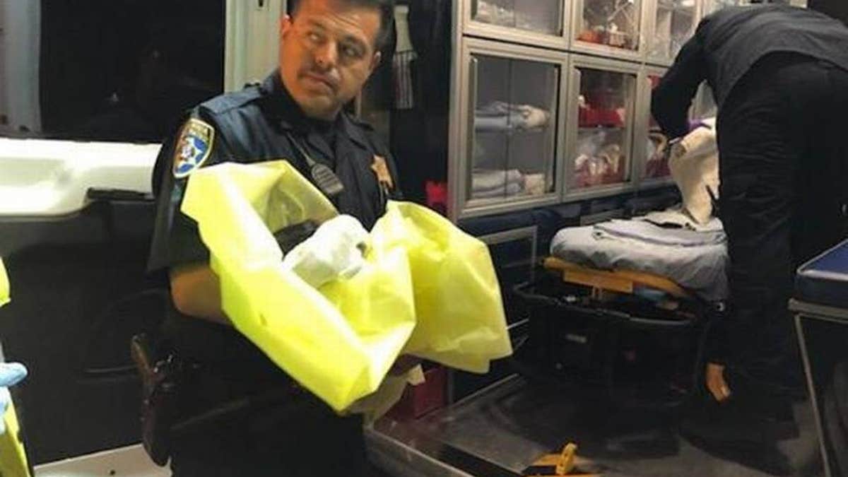 The California Highway Patrol's Alfred Medina holds the infant girl who was found in the town of Madera Ranchos.