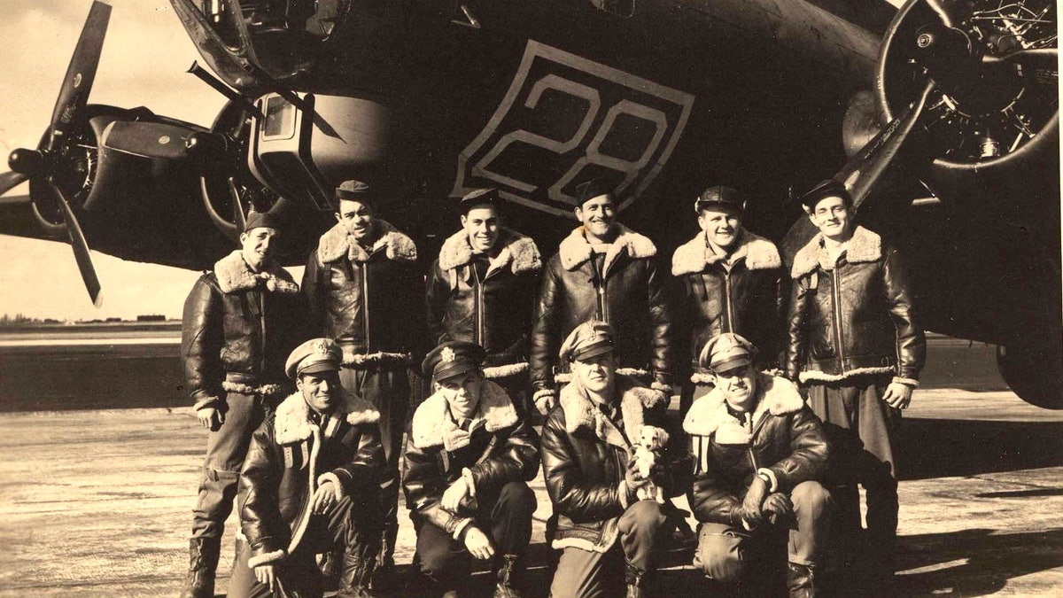 In this image provided by the Kriegshauser family and taken on Oct. 22, 1943 shows the crew posing for a photo in front of a training plane in Geiger Field in Spokane, Washington. They are back row from left: Stf Sgt. Harry Estabrooks, Sgt. Maurice Robbins, Stf Sgt. Robert Mayfield, Sgt. Vito Ambrosio, Sgt. Charles Tuttle and Sgt. George M. Williams. Front row from left: 2nd Lt. Melchor Hernandez, 2nd Lt. John W. Humphrey, 2nd Lt. Lyle Curtis holding the mascot Peanuts and Lt. John G. Kriegshauser.