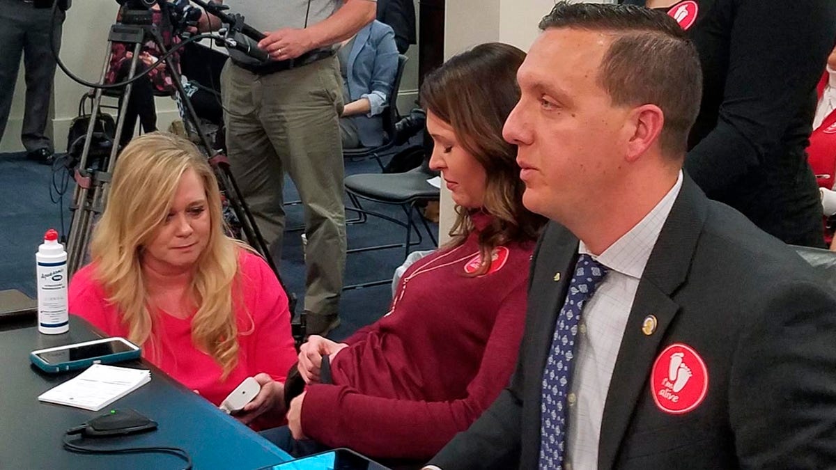 April Lanham, center, undergoes a procedure in Frankfort, Ky., that allows the audience at a Kentucky legislative meeting to hear her unborn son's heartbeat, Thursday, Feb. 14, 2019 in Frankfort, Ky. Her appearance came shortly before a Kentucky Senate committee advanced a bill that would ban most abortions in the state once a fetal heartbeat is detected. (Tom Latek/Kentucky Today via AP)