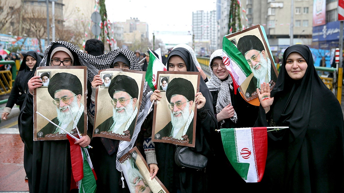 Iranian women hold up portraits of Iranian Supreme Leader Ayatollah Ali Khamenei, during a rally marking the 40th anniversary of the 1979 Islamic Revolution, in Tehran, Iran, Monday, Feb. 11, 2019. 