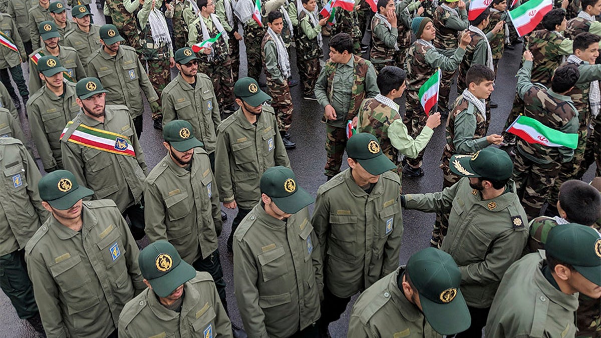 School students wave their national flags as Revolutionary Guard members arrive in Azadi, freedom square, during a ceremony celebrating the 40th anniversary of Islamic Revolution, in Tehran, Iran, on Monday.