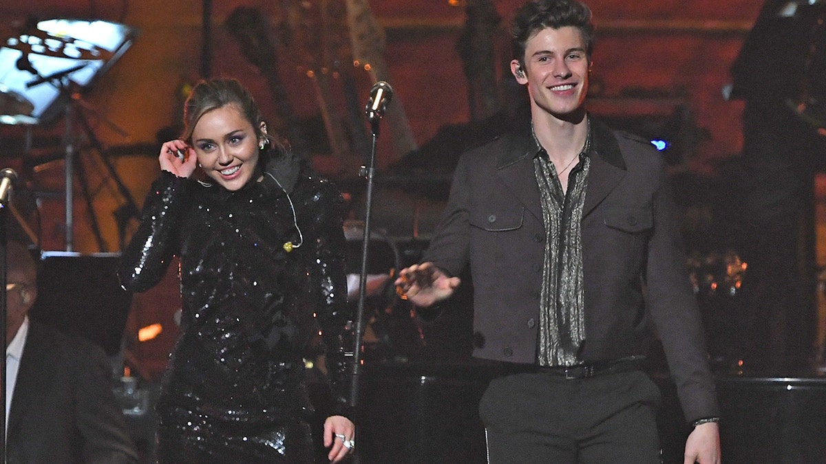 US singer Miley Cyrus (L) and Canadian singer-songwriter Shawn Mendes perform onstage at the 2019 MusiCares Person Of The Year gala at the Los Angeles Convention Center in Los Angeles on February 8, 2019. - The 2019 MusiCares honor US singer-songwriter Dolly Parton as the Person Of The Year. (Photo by Valerie MACON / AFP) (Photo credit should read VALERIE MACON/AFP/Getty Images)
