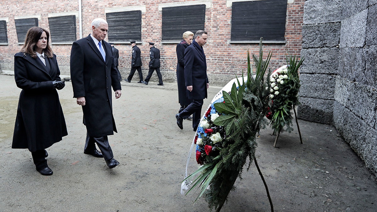 Vice President Mike Pence and his wife Karen Pence, left, walk with Poland's President Andrzej Duda and his wife Agata Kornhauser-Duda, right, to wreaths at a death wall during their visit at the Nazi concentration camp Auschwitz-Birkenau in Oswiecim, Poland, Friday. (AP Photo/Michael Sohn)