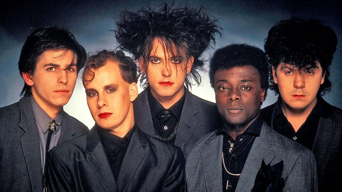 UNITED KINGDOM - JANUARY 01:  Photo of Phil THORNALLEY and CURE and Lol TOLHURST and Andy ANDERSON and Robert SMITH and Porl THOMPSON; L-R: Phil Thornalley, Porl Thompson, Robert Smith, Andy Anderson, Lol Tolhurst - posed, studio, group shot  (Photo by Fin Costello/Redferns)