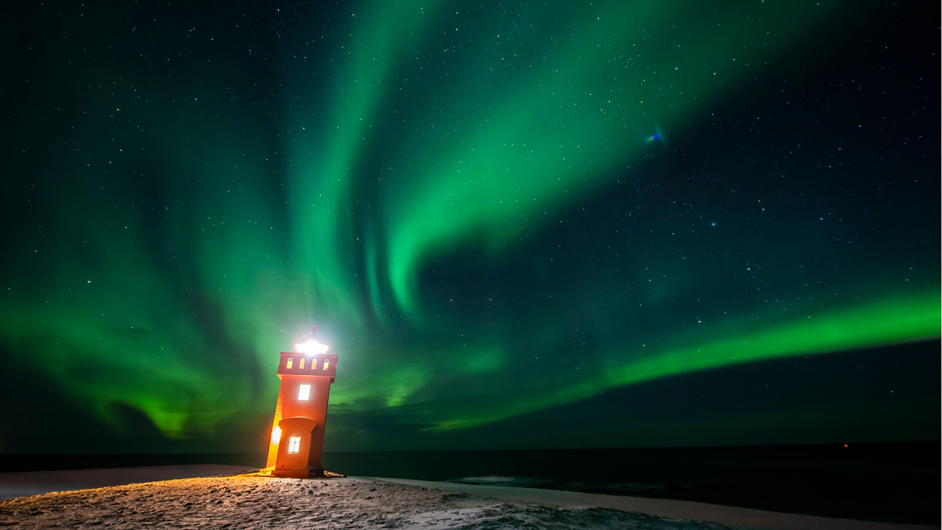 The aurora borealis or northern lights are visible in the sky above a lighthouse in the village of Grundarfjorour, Iceland, Feb. 4, 2019. 