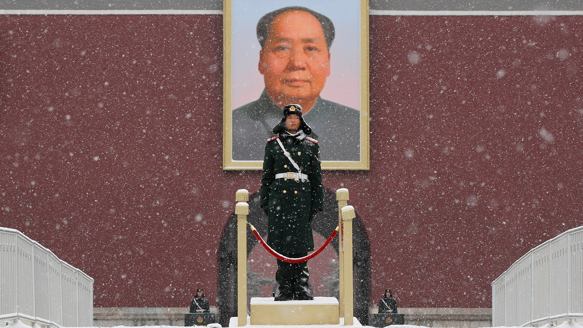 Chinese paramilitary policemen stand guard under the portrait of former leader Mao Zedong outside the Tiananmen Gate in Beijing, Feb. 12, 2019. 