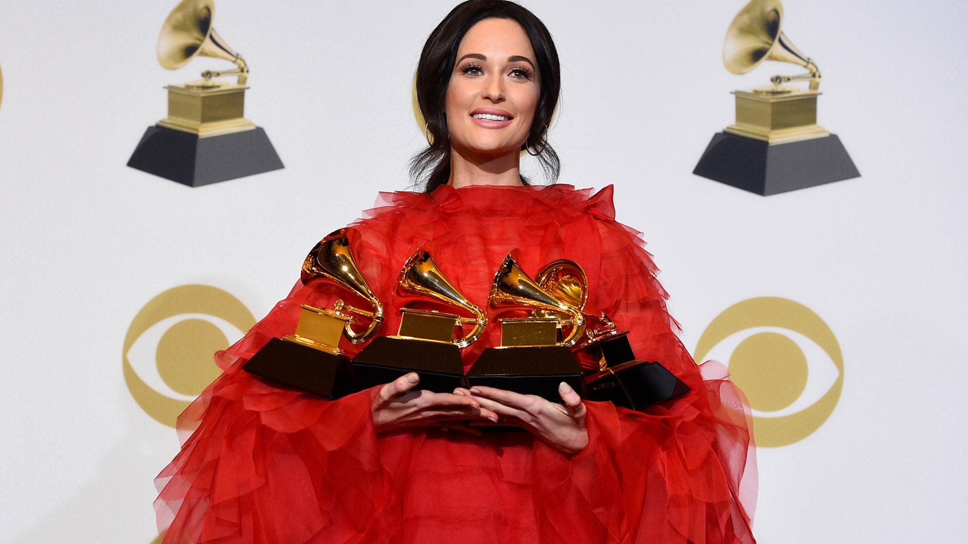 Kacey Musgraves, winner of the awards for best country album for "Golden Hour", best country song for "Space Cowboy," best country solo performance for "Butterflies" and album of the year for "Golden Hour" holds her trophies at the 61st annual Grammy Awards in Los Angeles, Feb. 10, 2019. 