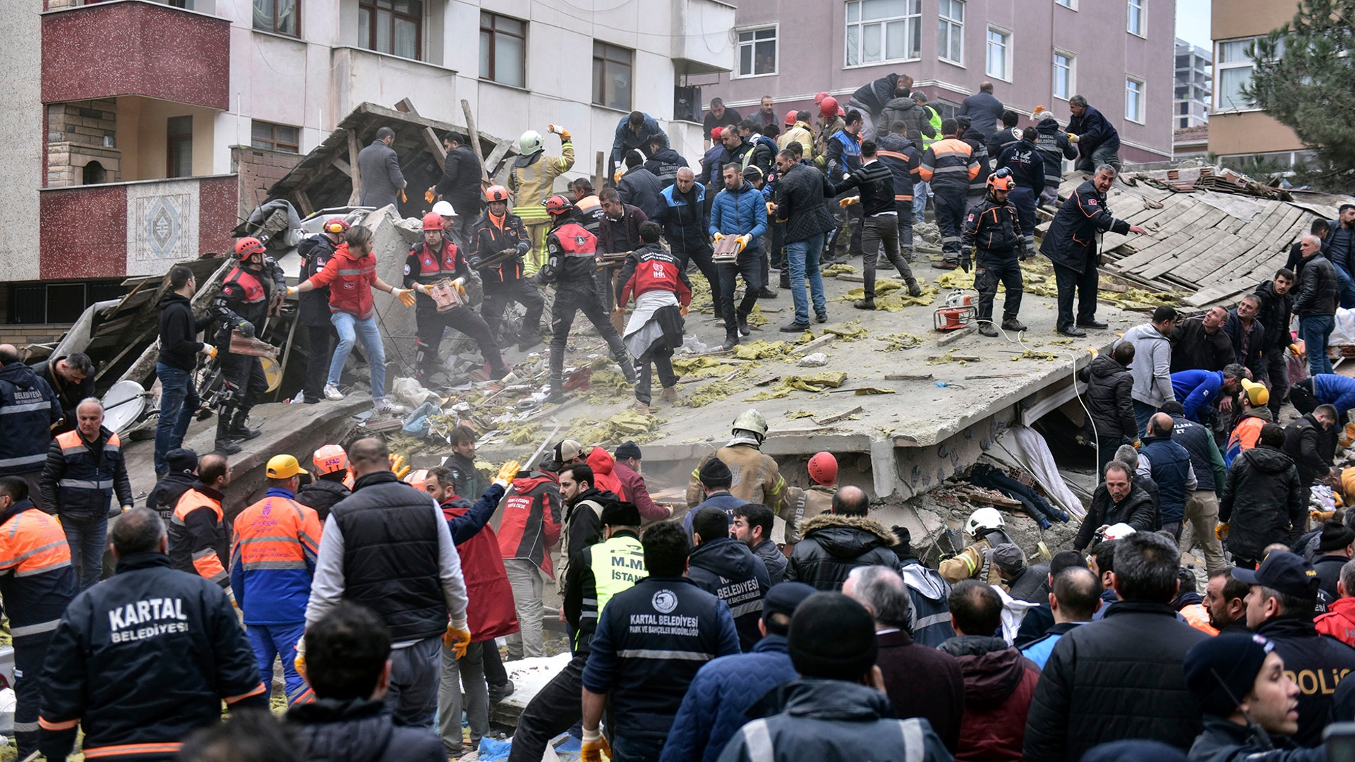 Rescue workers and people try to remove debris of an eight-story building which collapsed in Istanbul, Feb. 6, 2019. 