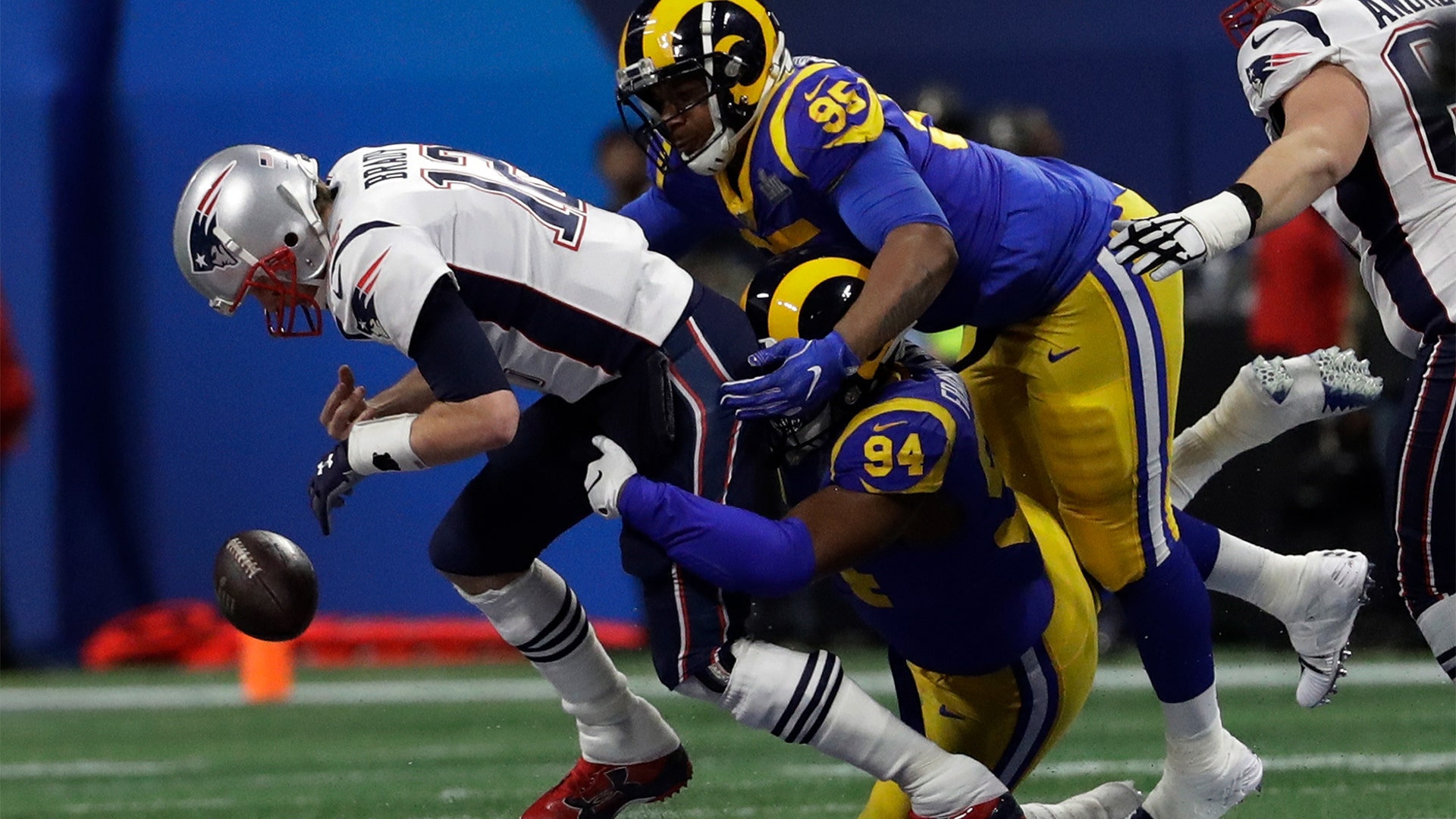 New England Patriots Tom Brady fumbles the ball under pressure from Los Angeles Rams' John Franklin-Myers and Ethan Westbrooks in the Super Bowl in Atlanta, February 3. 2019.