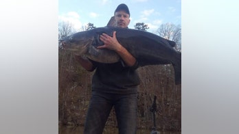 Fisherman reels in catfish 'almost as big as him,' releases it back into North Carolina lake