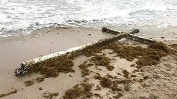 Giant wooden cross that washed up on Florida beach draws crowds