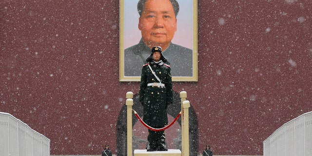Chinese paramilitary policemen stand guard under the portrait of former leader Mao Zedong outside the Tiananmen Gate as snow falls in Beijing, Tuesday, Feb. 12, 2019. The Pentagon cited competition from countries like China and Russia in its new strategy document on artificial intelligence. (AP Photo/Andy Wong)