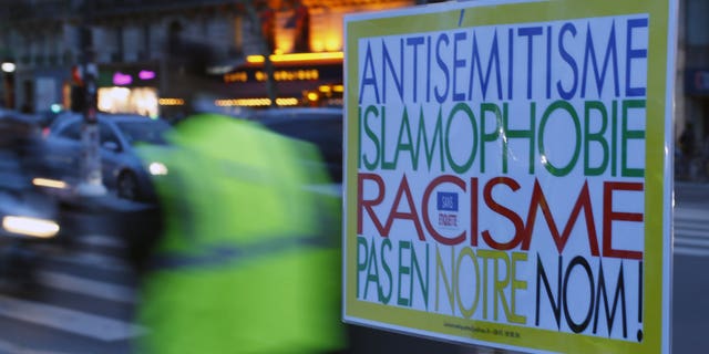 A poster reading "Anti-Semitism, Islamophobia, Racism, Not in Our Name" during a gathering decrying anti-Semitism at Place de la Republique in Paris, Monday, Feb. 18, 2019 amid an upsurge in anti-Semitism in France.